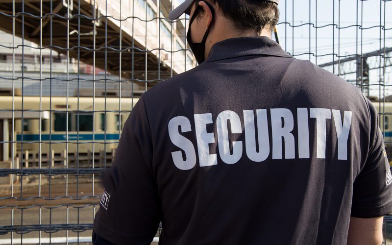 A back view of a security guard in uniform patrolling a residential area